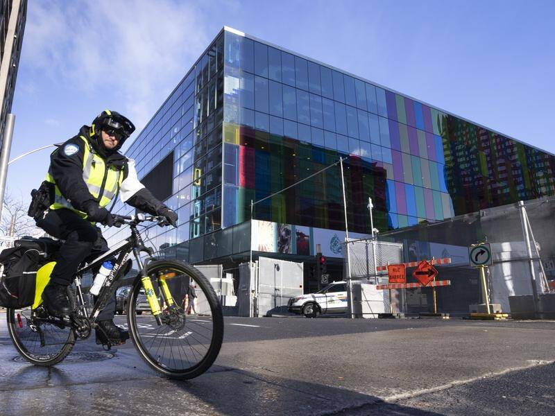 A police officer rides past the perimeter of the venue for the COP15 UN conference in Montreal. (AP PHOTO)