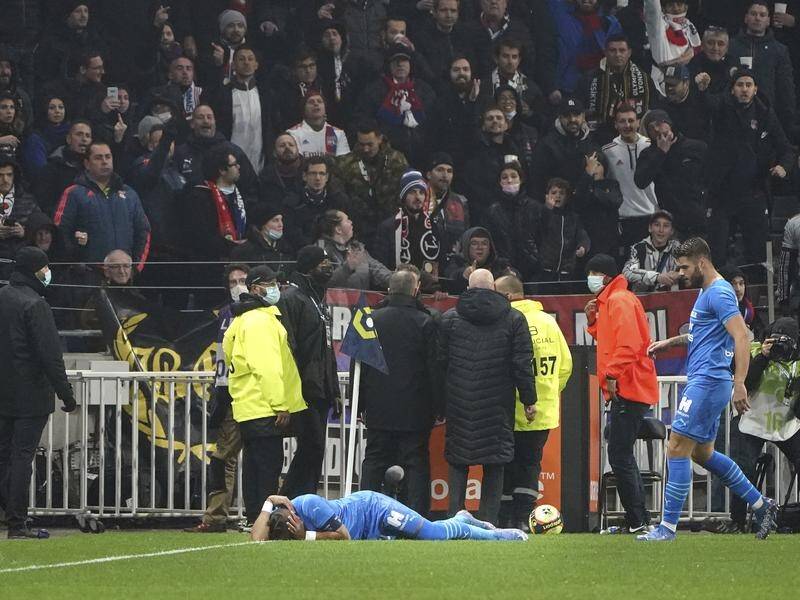Marseille's Dimitri Payet lies on the ground after being hit by an object thrown by a Lyon fan.