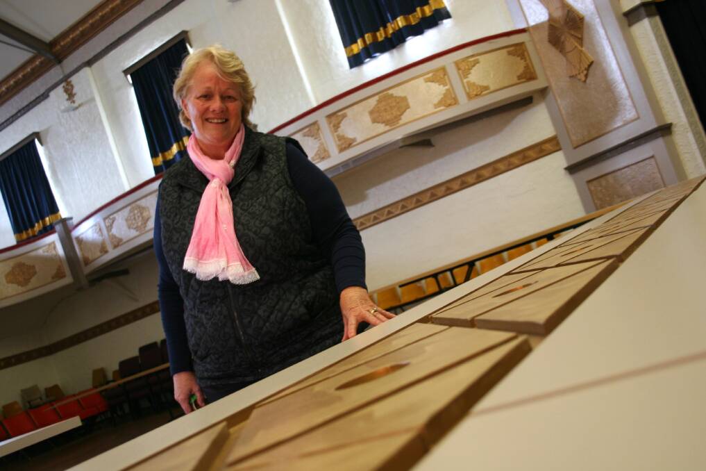 Friends of the Athenium secretary Barbara Manwaring with the new proscenium which will be mounted around the theatre's stage and curtain. Picture: Declan Rurenga