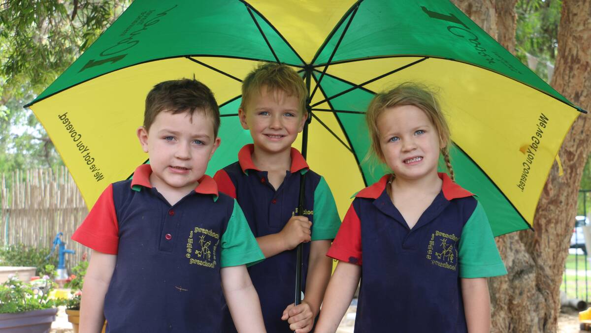 WET WEATHER: Four-year-olds Joshua Sweeney, Hudson McAlister and Olivia Salmon stay dry as rain dampens their play time at Junee Preschool. Picture: Jessica McLaughlin