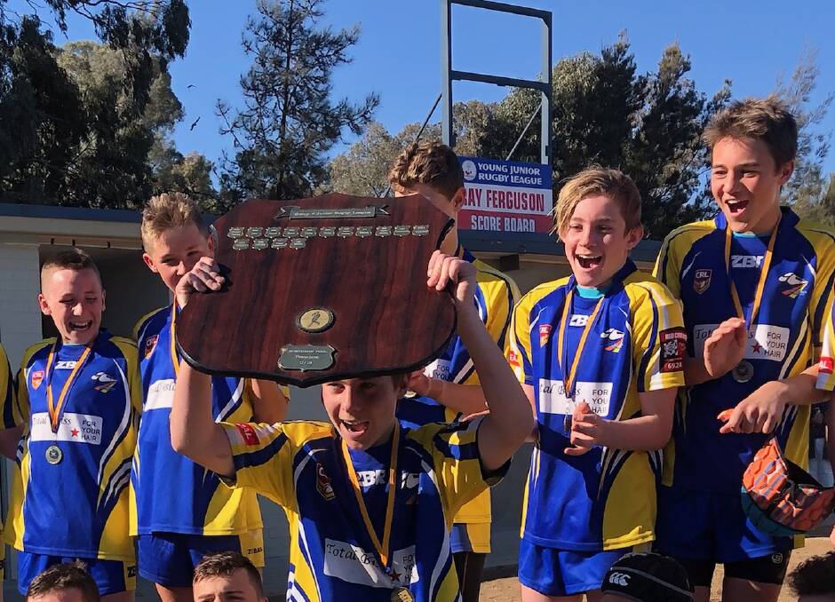 VICTORY: The boys celebrate their big win, raising the shield and showing off their blue and gold colours with pride. Picture: Contributed