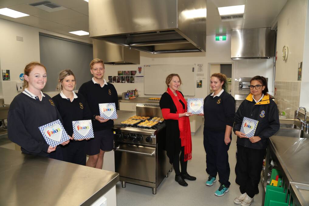 Junee students Elizabeth Eccleston (left), Olivia Herbert, Tom Snudden, Libby O'Regan and Melanie Garlick with their copy of Fusion presented by Booranga Writer's Centre creative director Kate Dunn (centre). Picture: Terry Vercoe